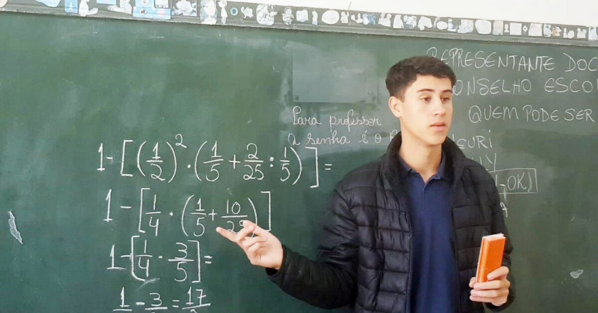 jovem professora ensinando aula de matemática para alunos na sala