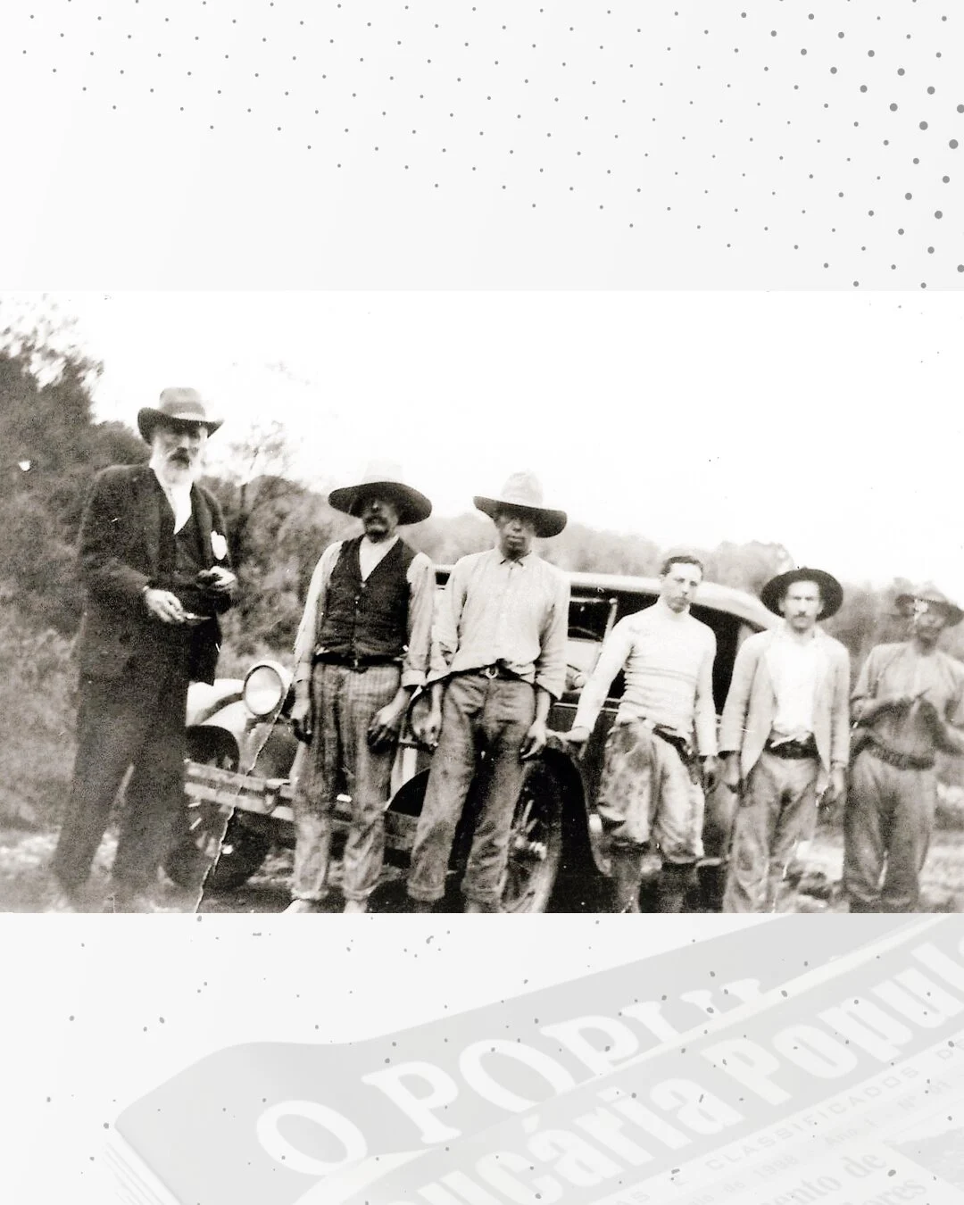 Seis homens posam diante de um automóvel antigo, em fotografia histórica em preto e branco.