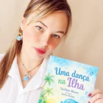 Mulher segura o livro infantil "Uma dança na Ilha", de Suellem Moura.
