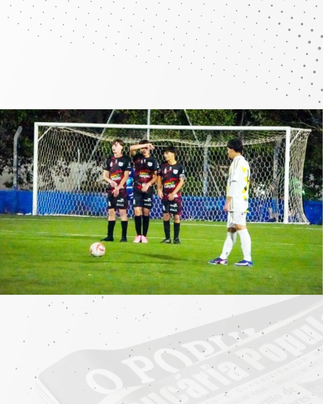 Três jogadores formam a barreira diante do gol enquanto outro se prepara para cobrar a falta.
